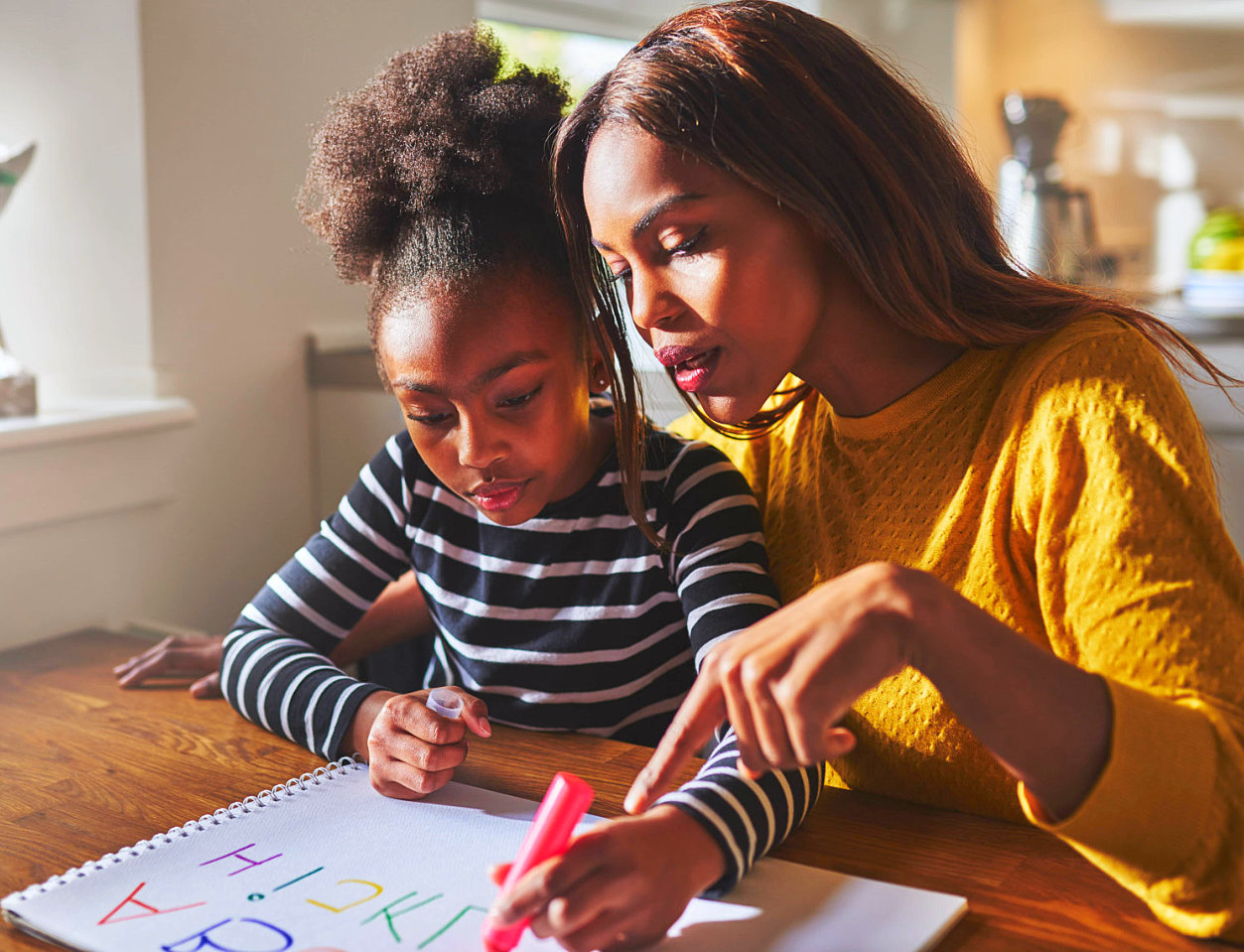 an adult woman teaching a female kid